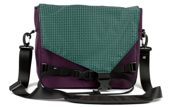 The Maker's Bag in Aubergine (dark purple) Ballistic with a Sitka (dark green with white grid) 200 Halcyon interior.